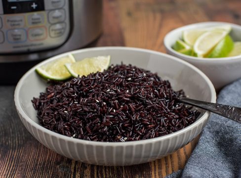 Pressure Cooker Black Rice prepared with limes and an Instant Pot in the background