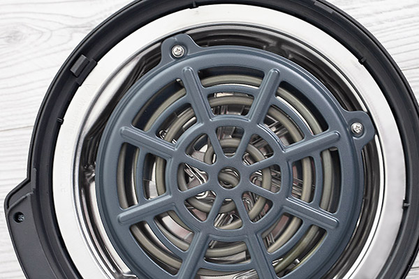 The underside of an Instant Pot Air Fryer Lid, with heating coil and guard.