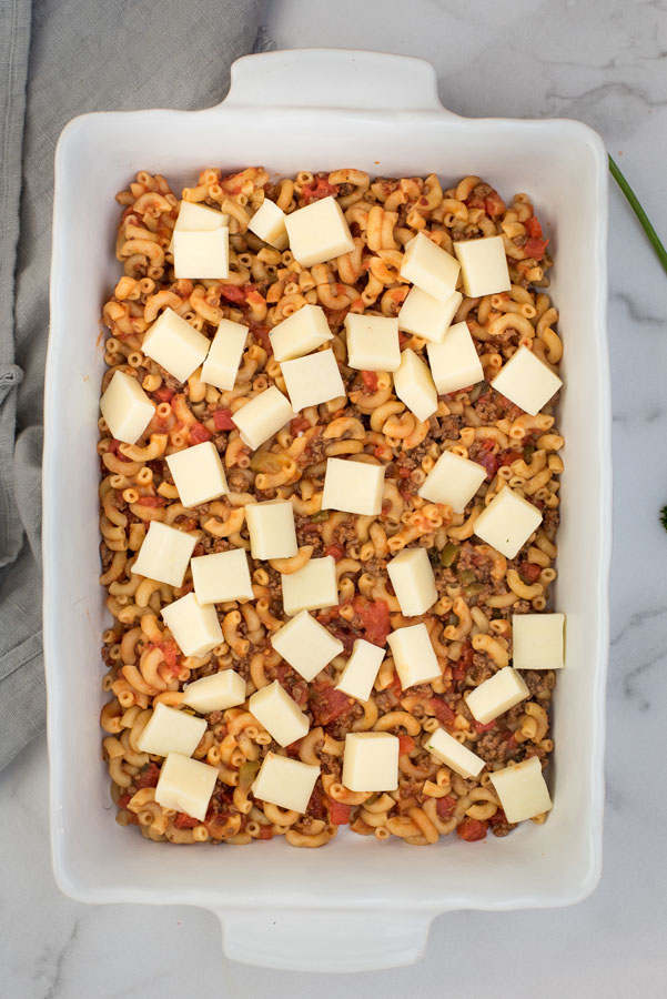 overhead of a ceramic white baking dish with American chop suey (beefaroni) in it, ready for baking