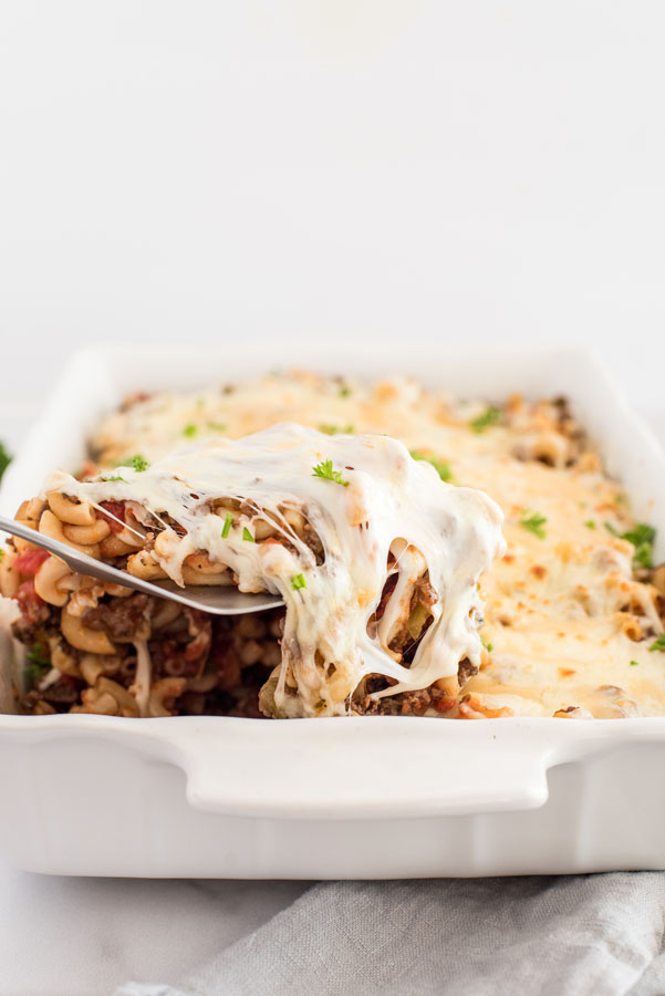 cheesy instant pot beefaroni / american chop suey with mozarella and gorund beef in a white baking dish