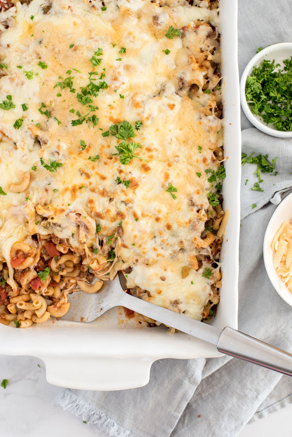 baked Instant Pot beefaroni casserole in white baking dish with serving spoon