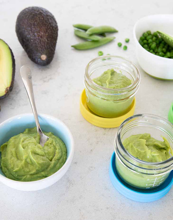 Baby food storage jars and a little dish with Sweet Pea and Avocado Puree from the Instant Pot Baby Food &amp; Toddler Food Cookbook