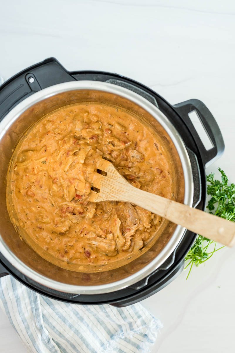 Paprika chicken cooked in an Instant Pot with a wooden spoon to serve.