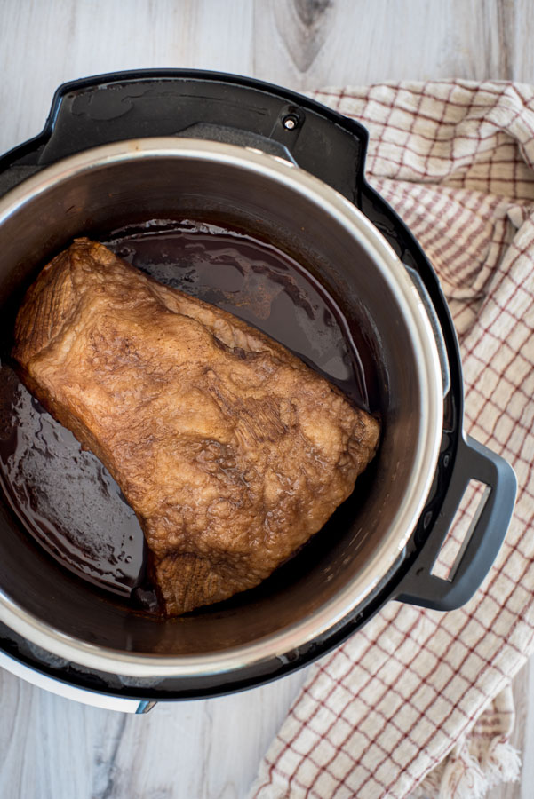 Beef brisket cooking inside an Instant Pot.
