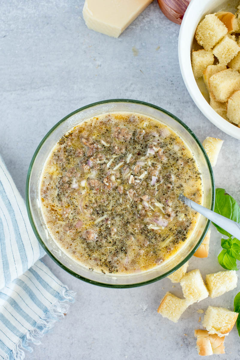 overhead of a glass bowl with all of the ingredients for caprese breakfast casserole