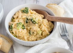 photo of Instant Pot cheesy chicken and broccoli casserole in a white bowl with a wooden spoon.