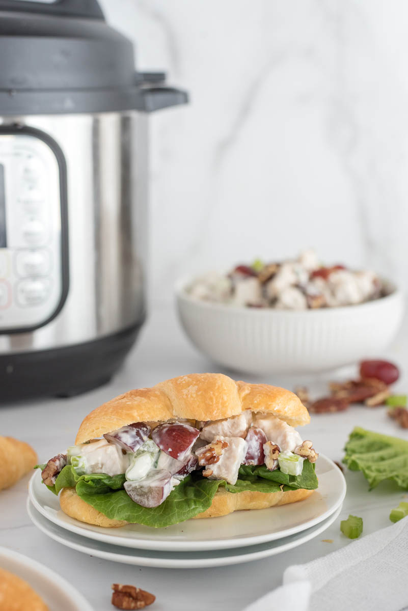 chicken salad sandwich on a plate in front of an instant pot pressure cooker