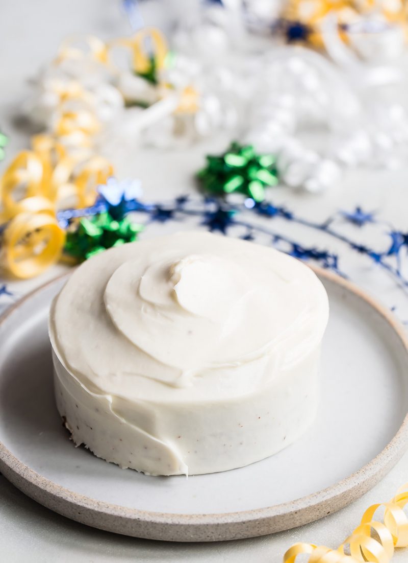 simple cake for two, with white frosting and ribbon swirls in the background