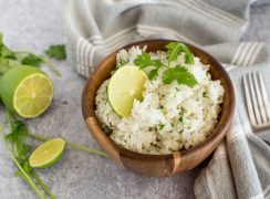 Instant pot cilantro lime white rice in a wooden bowl topped with fresh lime and cilantro