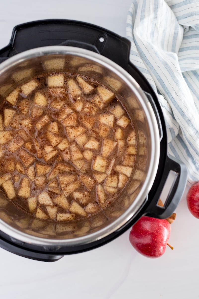 overhead of an instant pot with apples cooking in cinnamon