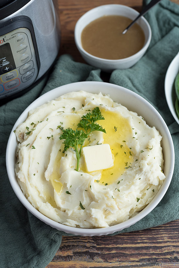 Overhead view of Instant Pot Mashed Potatos with an Instant Pot and turkey gravy in the background