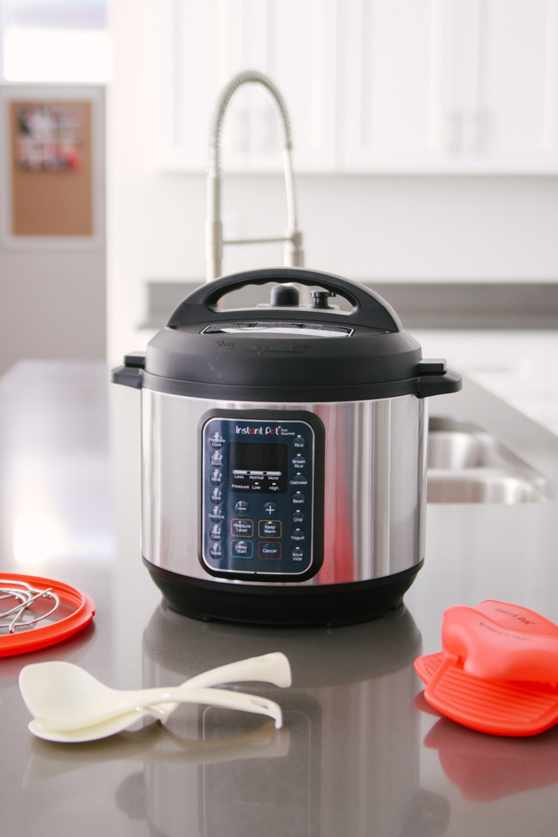 front shot of the Instant Pot Duo Gourmet with the lid in place with the accessories on the counter in front