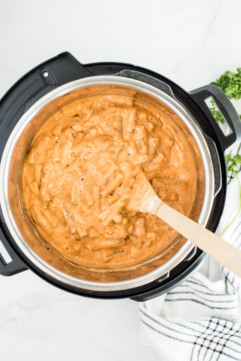 An overhead shot of the cooked Baked Ziti after adding the alfredo sauce and stirring until it is a lovely bright orange color.