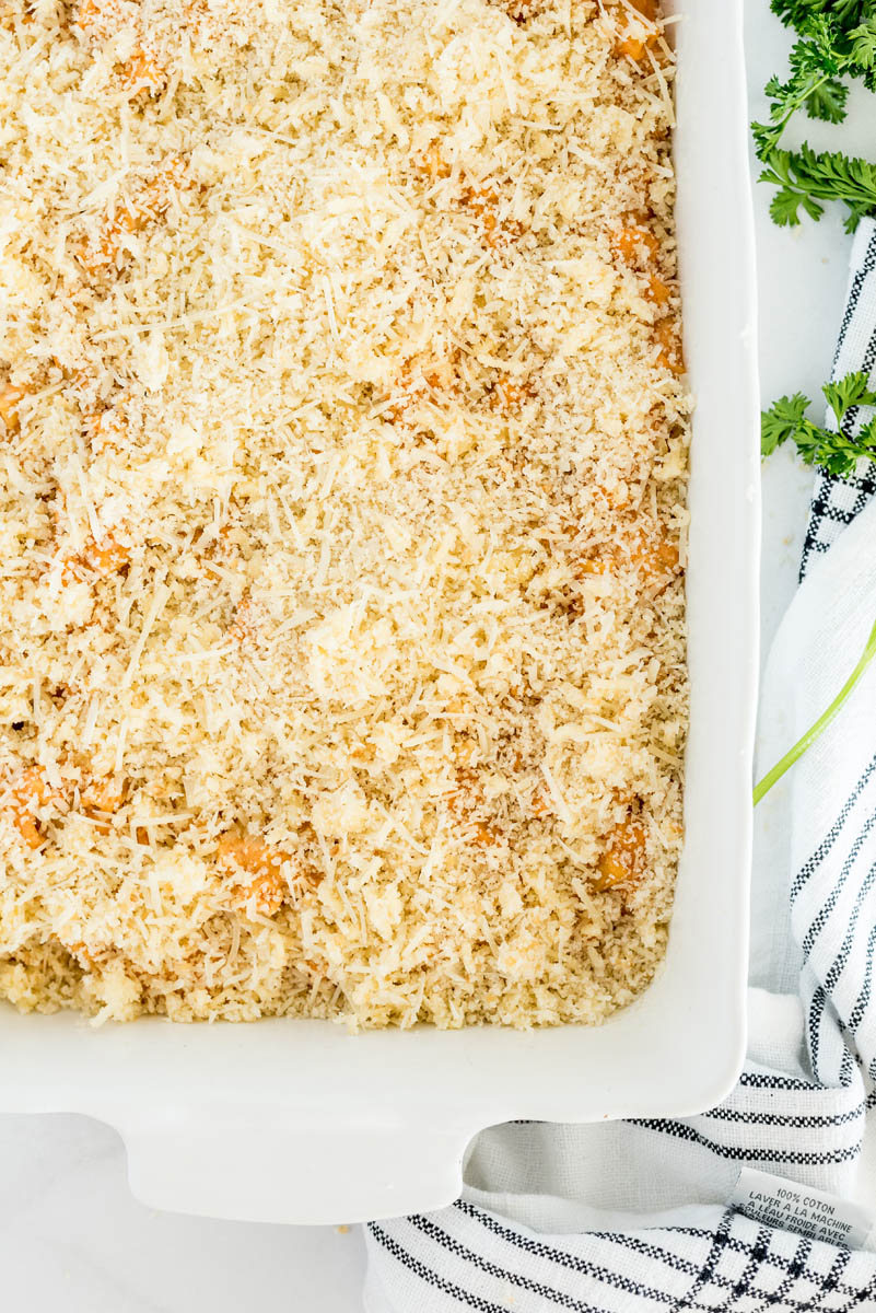 An overhead shot of the baked ziti topped with breadcrumbs before browning 