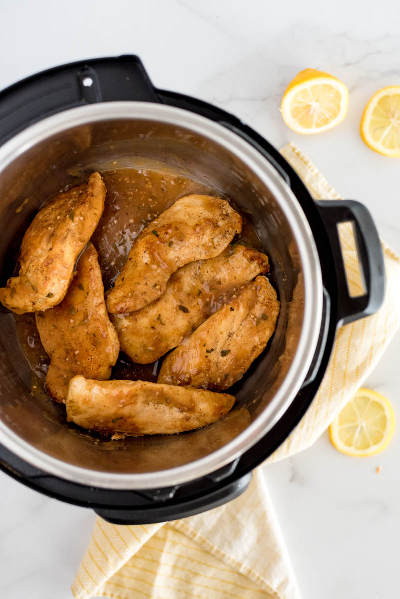 overhead of chicken breasts in an instant pot with lemons