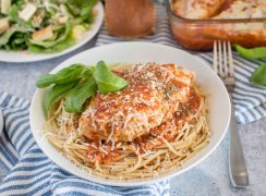 Close up shot of Instant Pot chicken marinara served over spaghetti and garnished with basil.