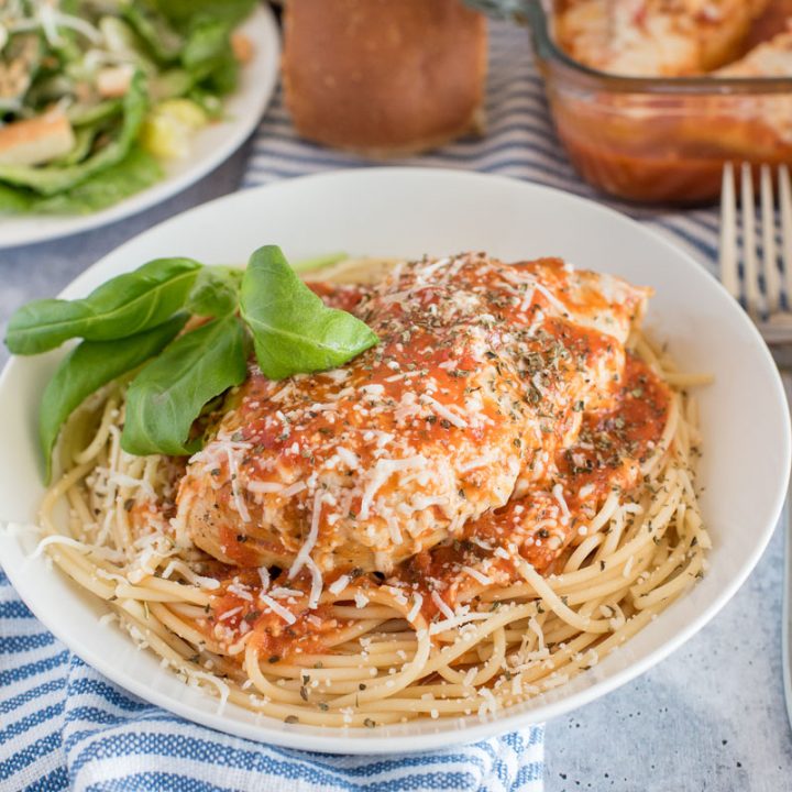 Close up shot of Instant Pot chicken marinara served over spaghetti and garnished with basil.