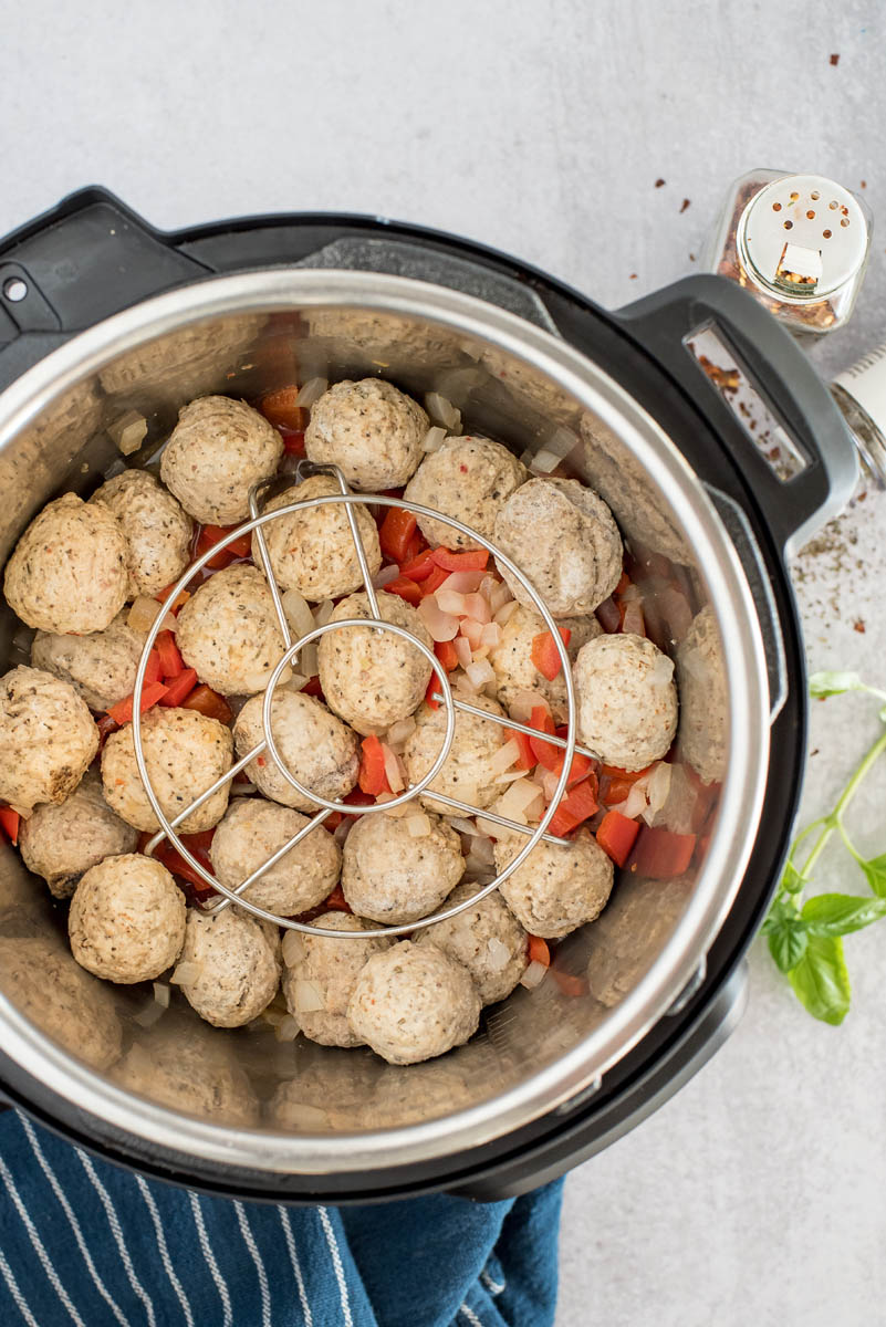 frozen meatballs in an instant pot with marinara sauce and a trivet