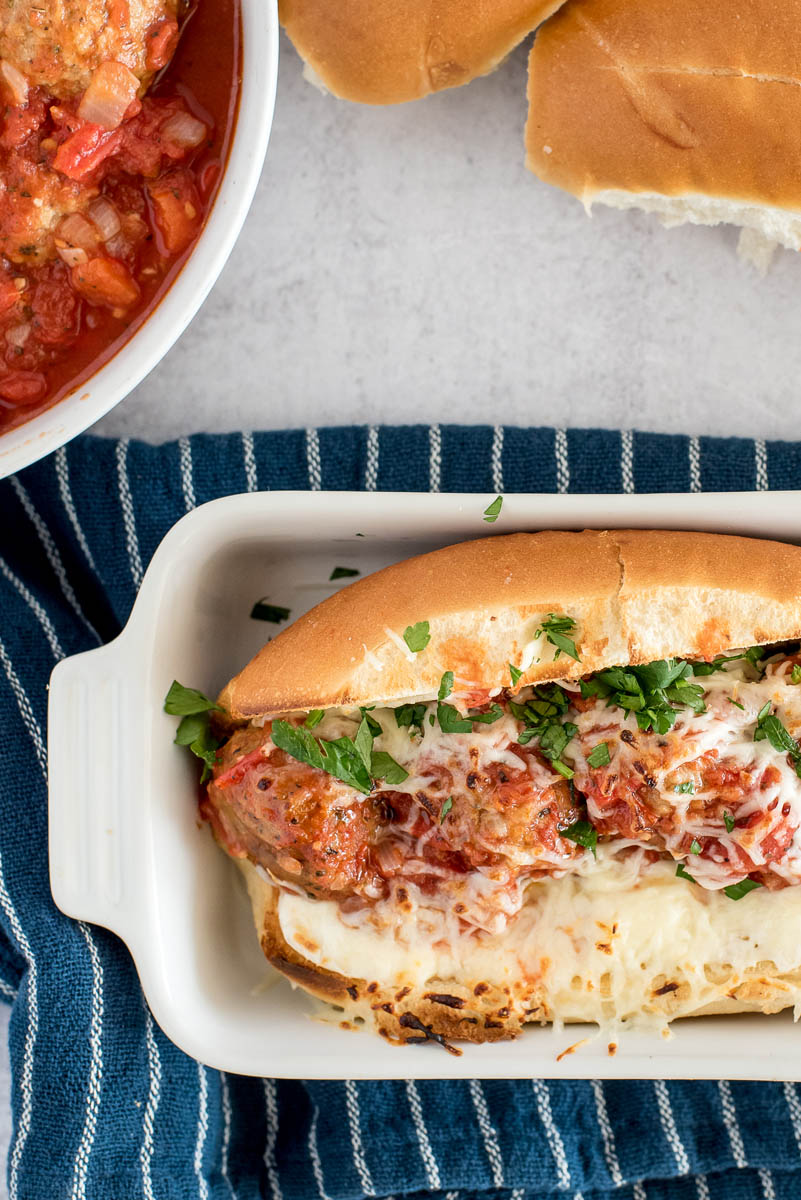 meatball sub in a white baking dish with cheese