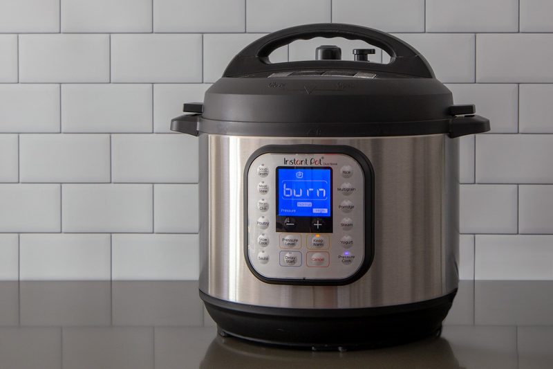 An Instant Pot Duo Nova on a gray counter displaying the burn notice on a blue digital screen