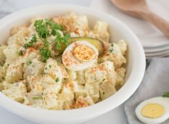 Instant pot potato salad garnished with fresh parsley and paprika in white bowl