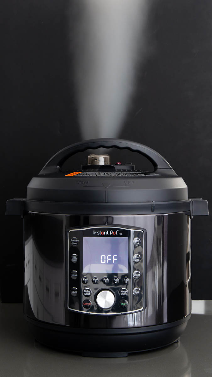 Instant Pot Pro steam release against a black background