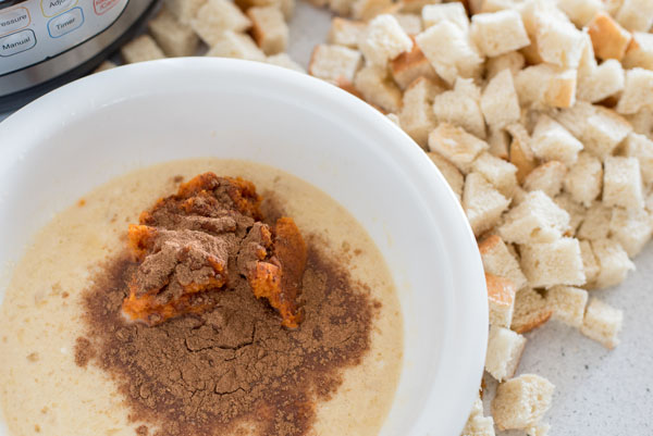 Mixing incredients for the pumpkin spice baked french toast, with Challah bread and an Instant Pot in the background