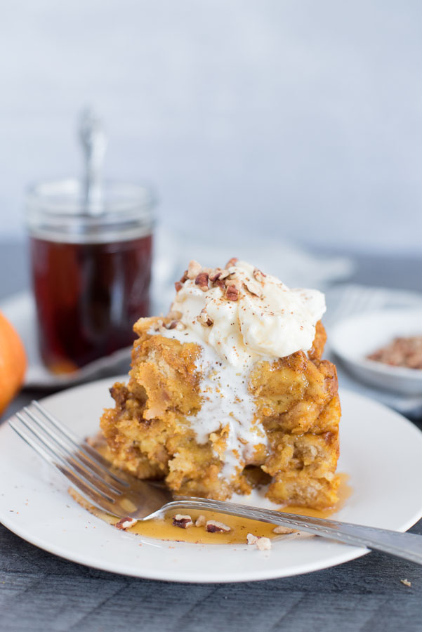 Profile view of Instant Pot / Pressure Cooker Pumpkin Spice Baked French Toast recipe with maple syrup in the background.