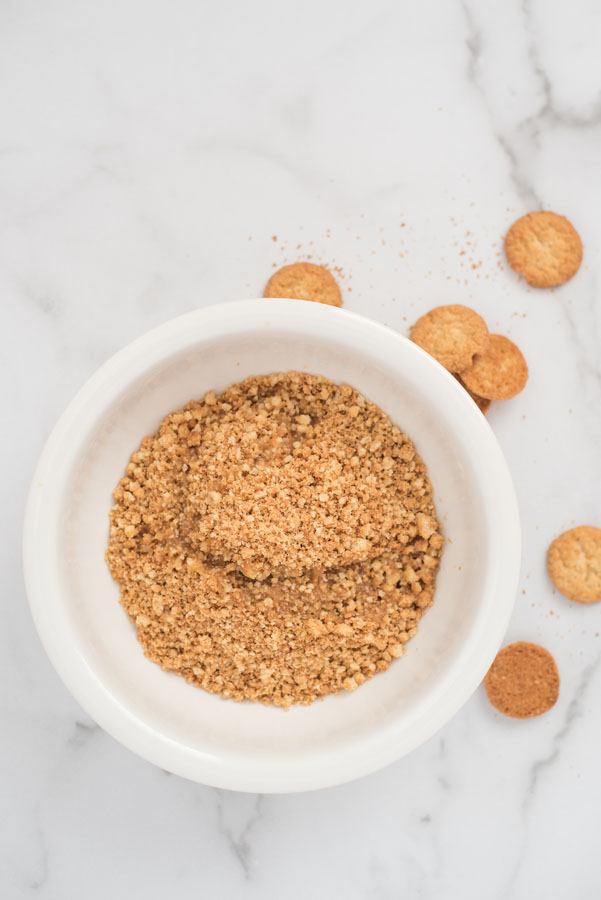 Overhead shot of a bowl of crushed lemon cookies to make pressure cooker cheesecake crust.