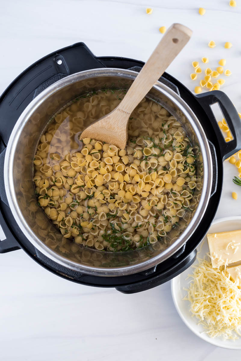 overhead of an instant pot with uncooked bacon mac and cheese