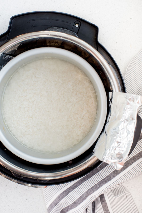 White rice in a 7 inch cake pan placed over the rosemary cashew chicken to cook pot in pot at the same time.