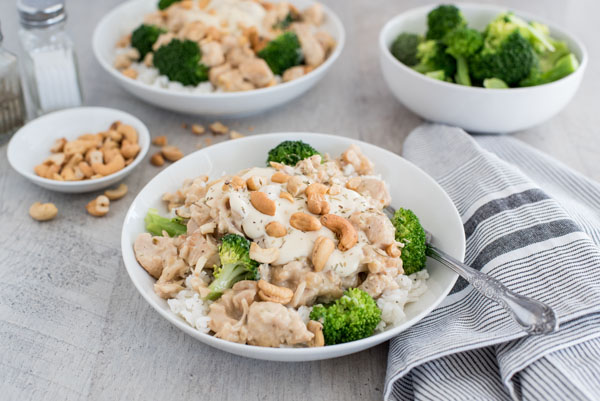 45 degree shot of rosemary cashew chicken in a serving bowl with rice and broccoli.