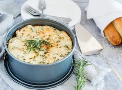 freshly made Instant pot white chicken alfredo lasagna in a round springform pan with a sprig of rosemary and breadsticks