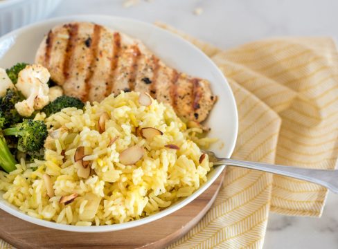 saffron rice pilaf with grilled chicken in a white bowl