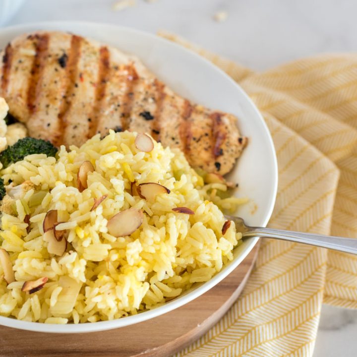 saffron rice pilaf with grilled chicken in a white bowl