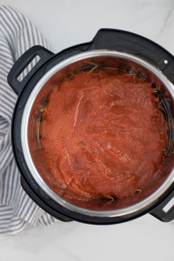 overhead of an instant pot with tomato sauce to make pressure cooker spaghetti and meatballs