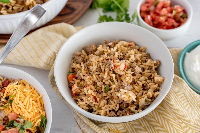 bowl of taco rice with toppings on the side