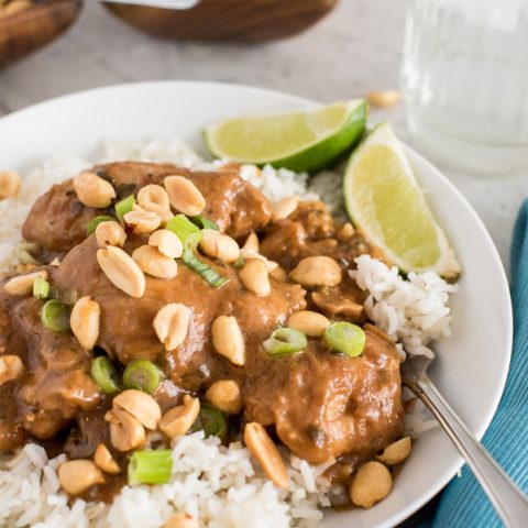 pressure cooker thai chicken thighs with peanut sauce on white rice with a lime wedge
