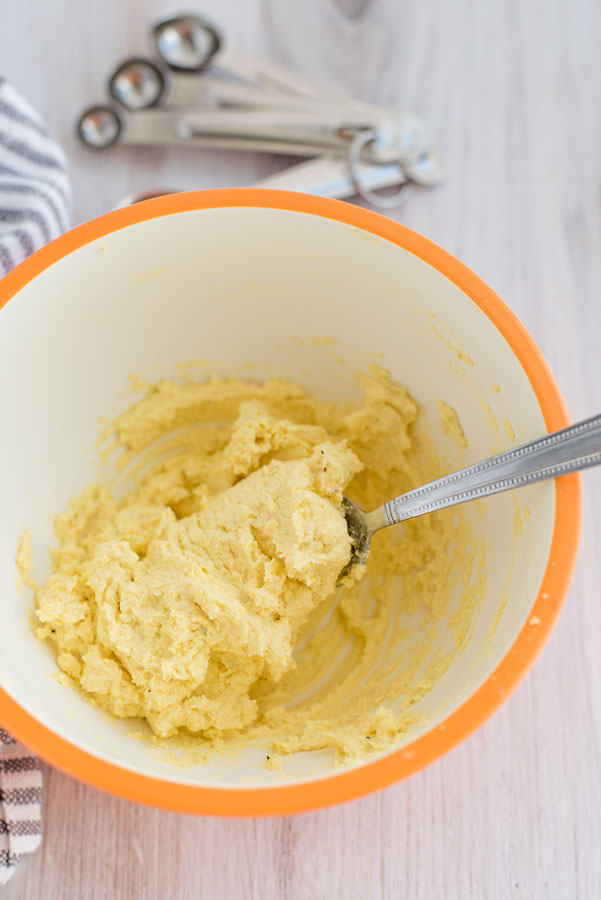 Close up on a fork stirring up Instant Pot deviled egg filling made with hard-boiled egg yolks, flavored mustard, Greek yogurt and mayonnaise.