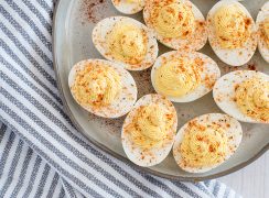 Overhead of a ceramic plate with 10 half hard-boiled eggs made in an electric pressure cooker filled with deviled egg yolk filling