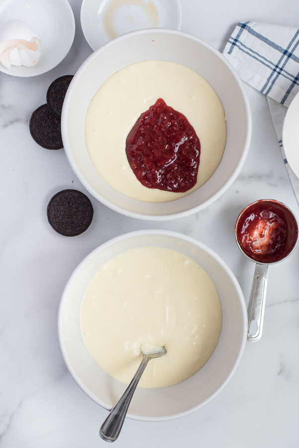 Separating the cheesecake batter to mix in the strawberry sauce to half of the batter for a layered pressure cooker cheesecake.