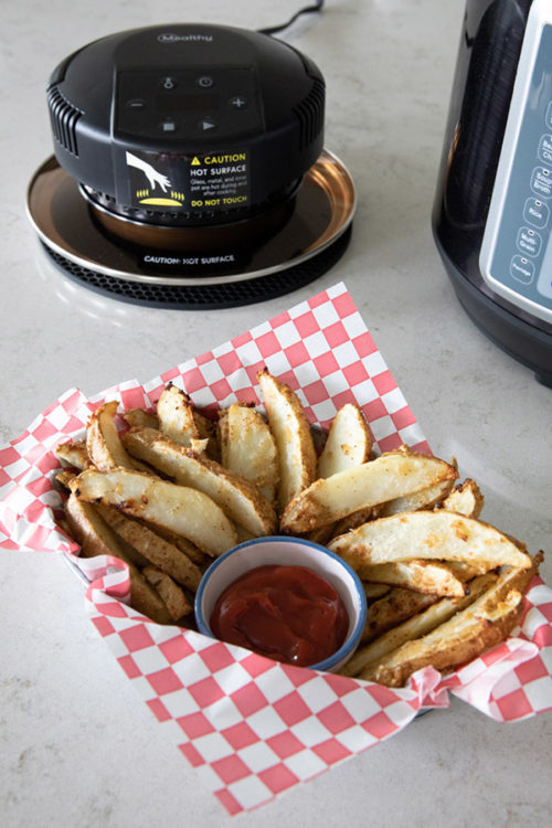 Basket of wedge fries and ketchup in front of Mealthy CrispLid