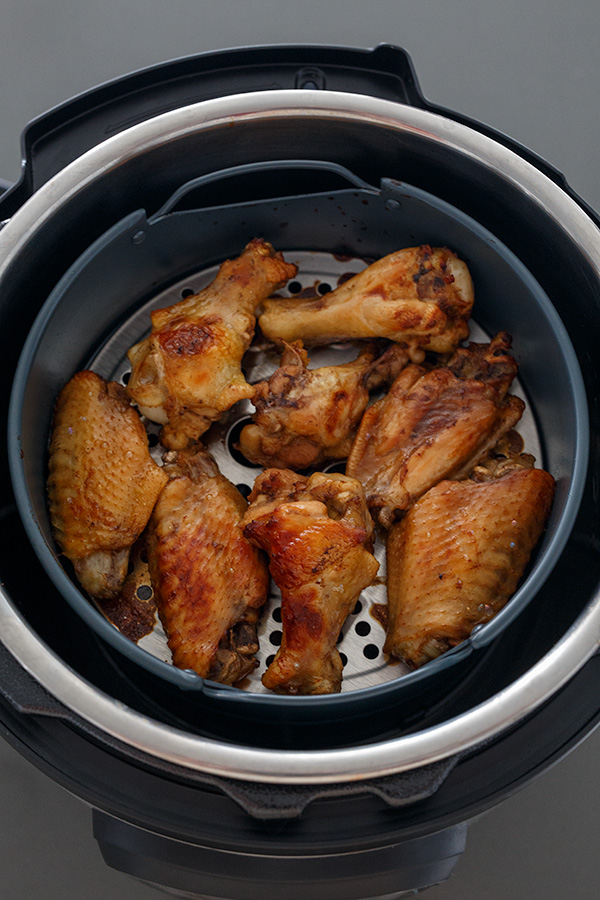 Teriyaki chicken wings browned up with the Instant Pot Air Fryer Lid in an air fryer basket.