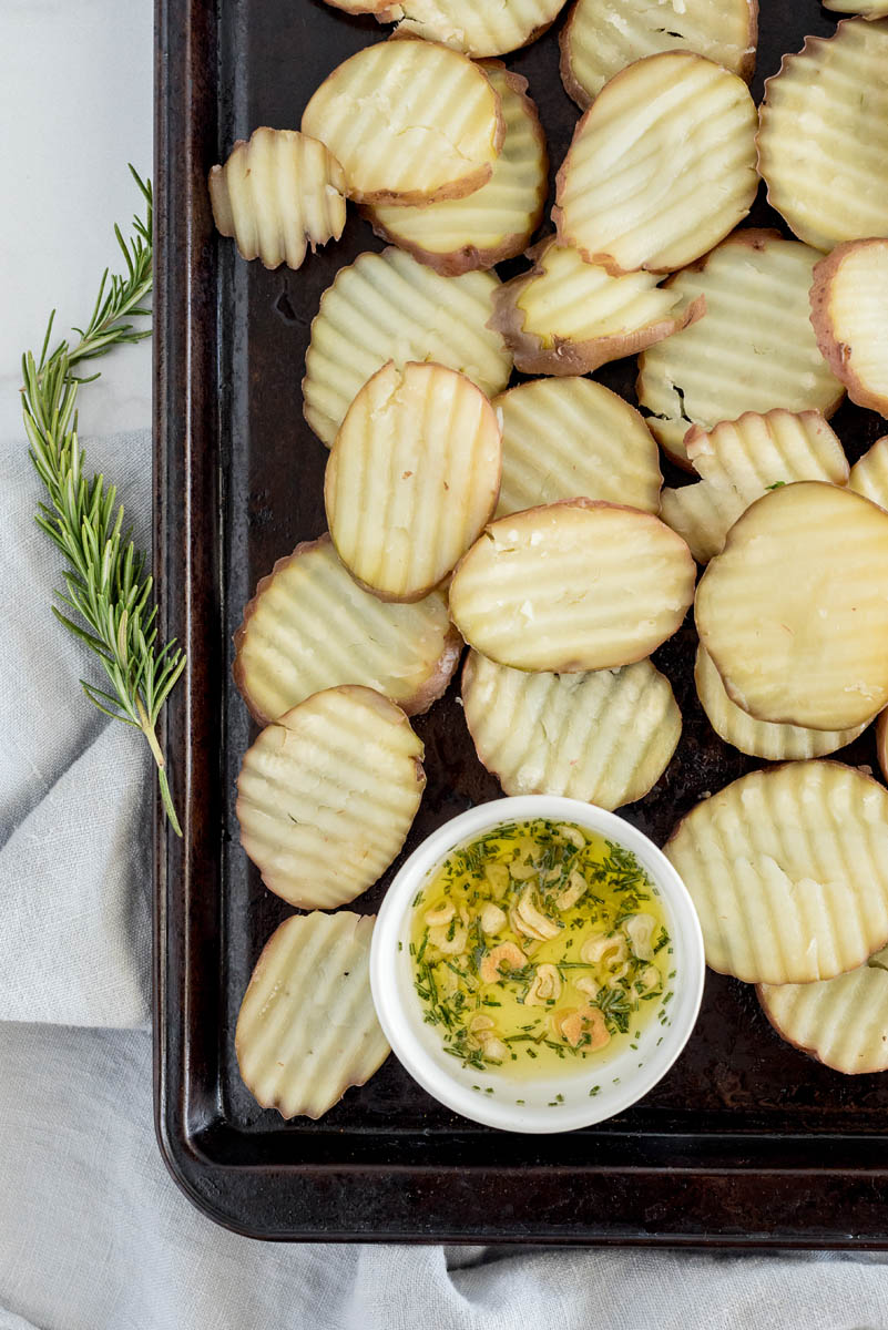 a shot of the garlic and rosemary and oil all tossed together on a baking sheet