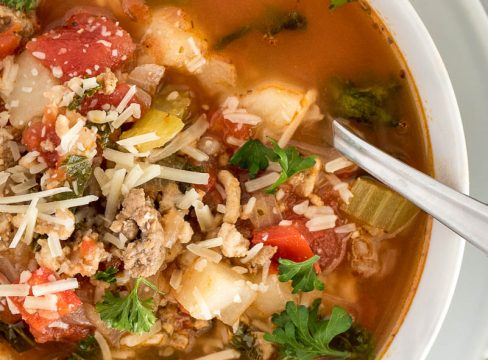 close up on bowl oftomatosoup with sausage and potatoes