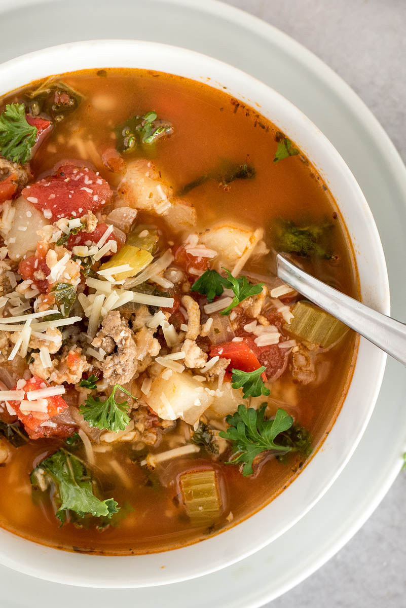 close up on bowl oftomatosoup with sausage and potatoes