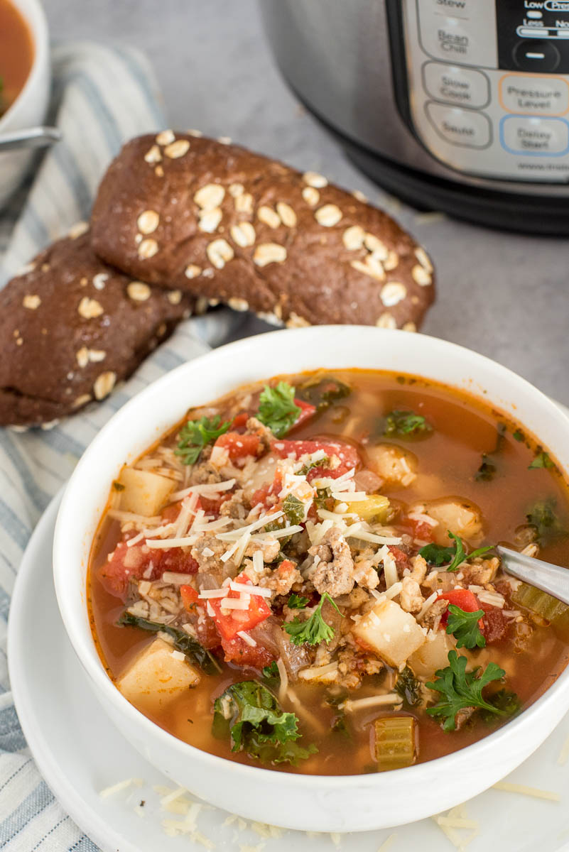 bowl of sausage potato soup with bread 