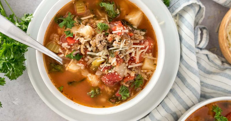 bowl of sausage and potato soup with cheese on top