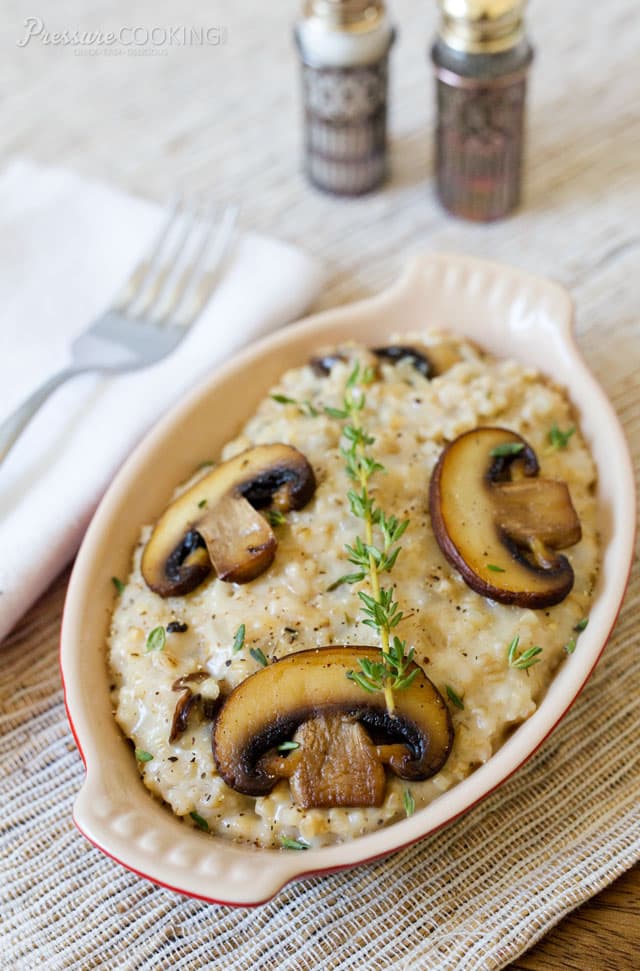 dish of savory mushroom thyme oatmeal garnished with sliced mushrooms and fresh thyme