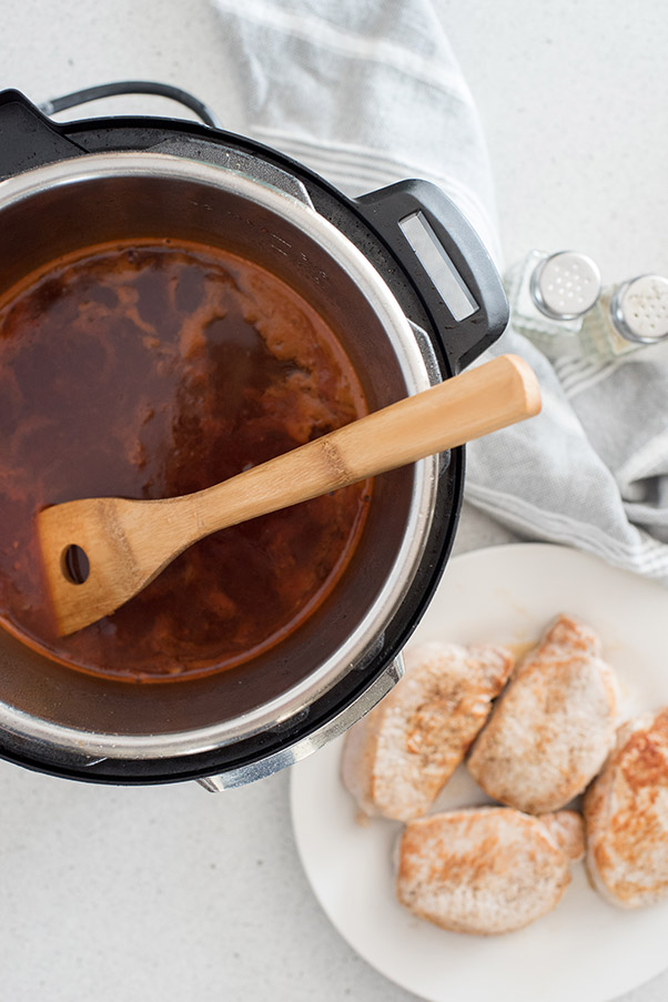 Instant Pot Boneless Pork Chops, browned and ready to add to the liquid inside the pressure cooking pot